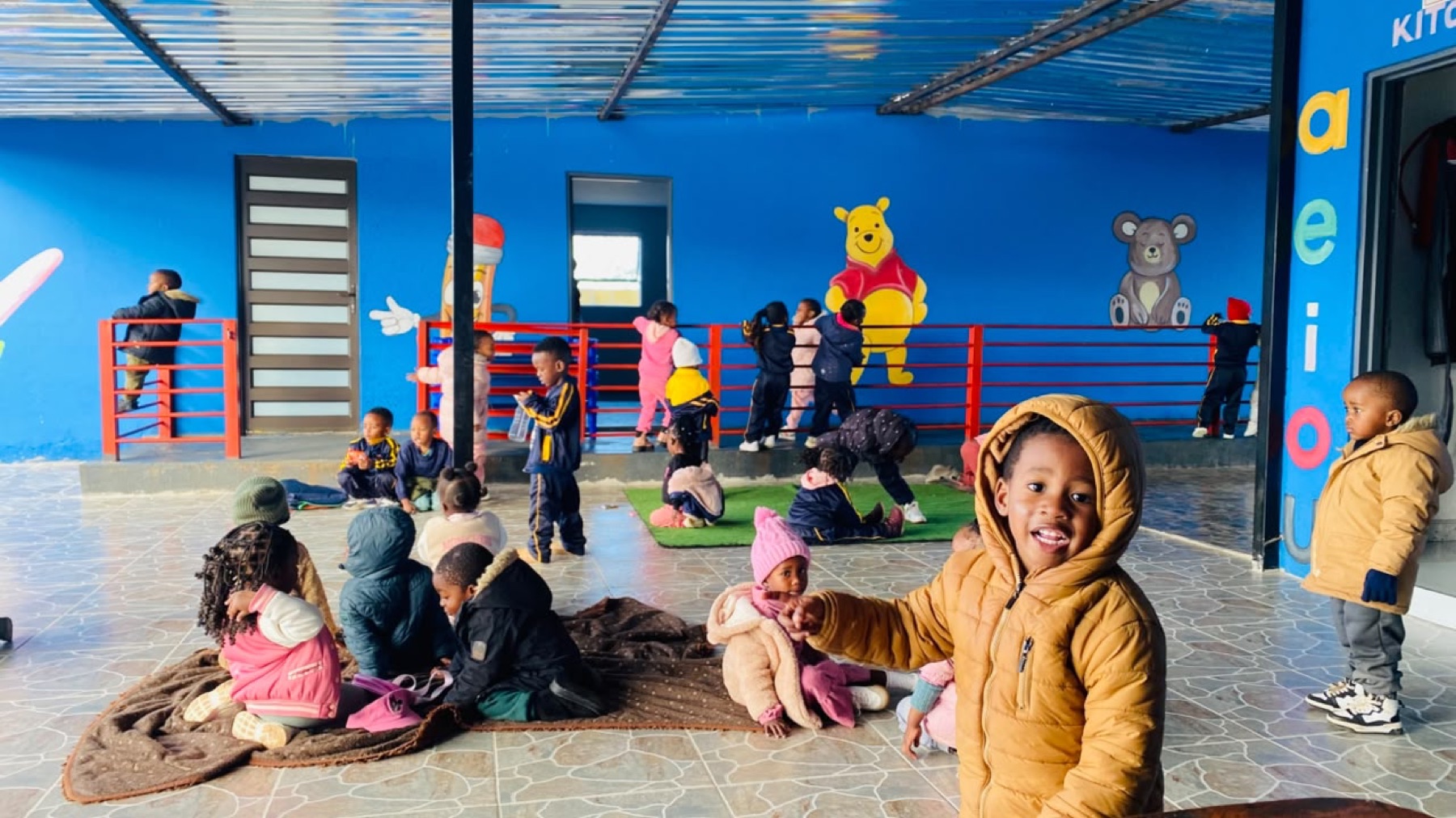 Children gathered on blankets on the veranda on a winter morning